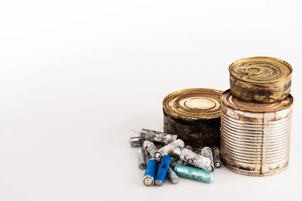 Latas enferrujadas de metal e baterias usadas no fundo branco — Fotografia de Stock