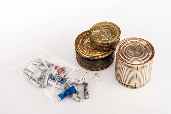 Latas oxidadas de metal y baterías usadas sobre fondo blanco - foto de stock