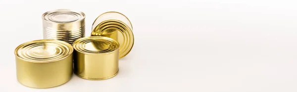 Metal golden tins on white background, panoramic shot — Stock Photo