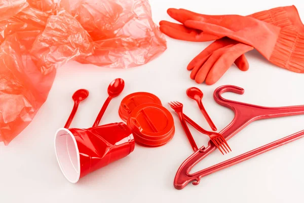 Objets en plastique rouge dispersés sur fond blanc — Photo de stock