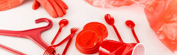 Oggetti di plastica rossa sparsi su sfondo bianco, colpo panoramico — Foto stock