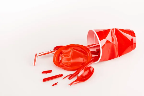Objetos de plástico vermelho quebrado no fundo branco — Fotografia de Stock