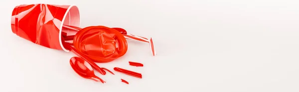 Zerbrochene rote Kunststoffgegenstände auf weißem Hintergrund, Panoramaaufnahme — Stockfoto
