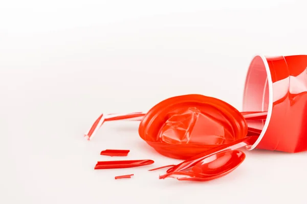 Objets en plastique rouge cassé sur fond blanc — Photo de stock