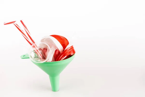 Red plastic objects in funnel on white background — Stock Photo