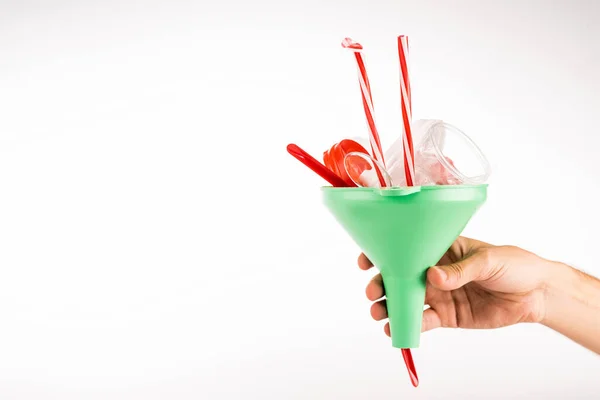 Cropped view of man holding funnel with plastic objects on white background — Stock Photo
