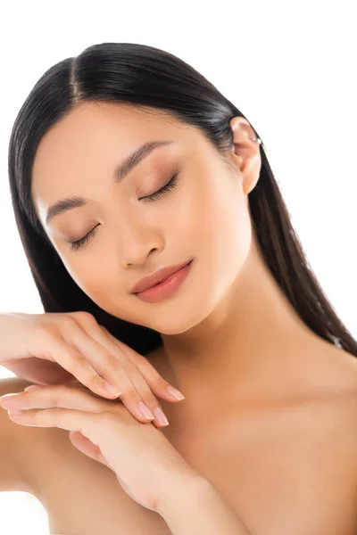 Portrait of young asian woman with closed eyes touching her hands isolated on white — Stock Photo