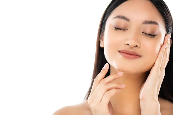 Giovane donna asiatica con gli occhi chiusi toccare faccia isolata su bianco — Foto stock