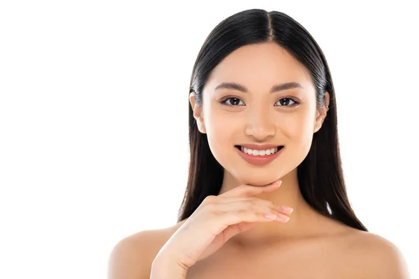 Eccitato giovane donna asiatica guardando la fotocamera e toccando il viso isolato su bianco — Foto stock