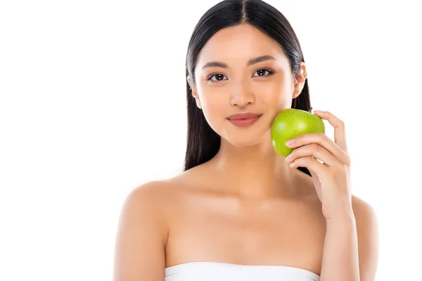 Joven mujer asiática mirando a la cámara y sosteniendo manzana aislada en blanco - foto de stock