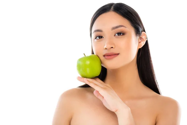 Joven mujer asiática mirando a la cámara y sosteniendo manzana aislada en blanco - foto de stock