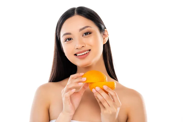 Nua mulher asiática olhando para a câmera enquanto segurando cortado laranja isolado no branco — Fotografia de Stock