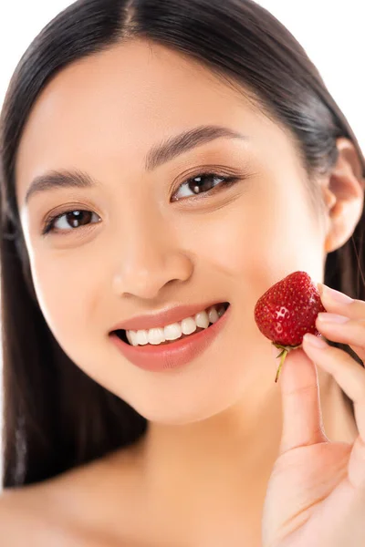 Selektiver Fokus der asiatischen Frau, die reife Erdbeeren in Gesichtsnähe hält, isoliert auf Weiß — Stockfoto