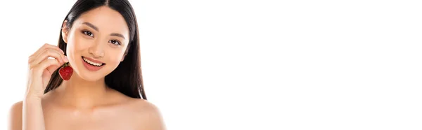 Горизонтальне зображення оголеної азіатки, що тримає стиглу полуницю біля обличчя ізольовано на білому — стокове фото