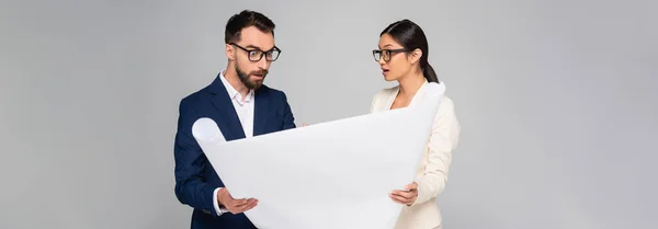 Horizontal image of interracial couple of businesspeople holding placard isolated on grey — Stock Photo