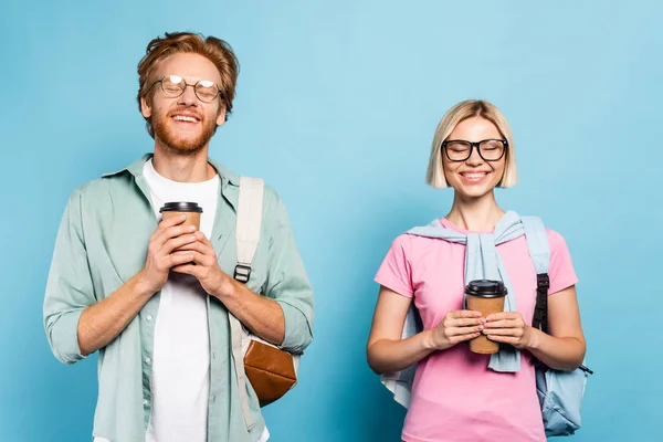 Junge Studenten in Gläsern mit geschlossenen Augen, die Pappbecher auf blau halten — Stockfoto