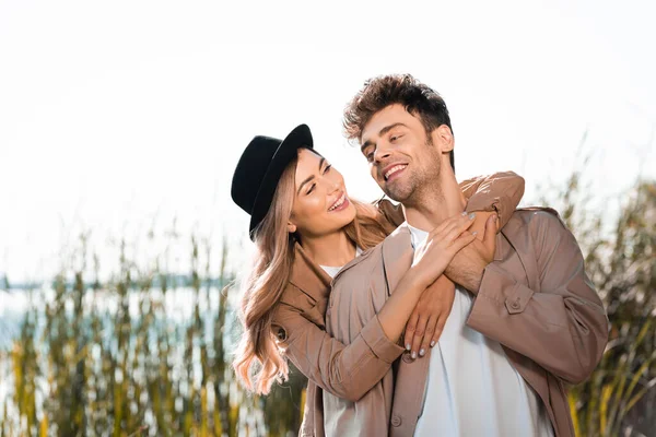 Blonde woman in hat and man embracing outside — Stock Photo