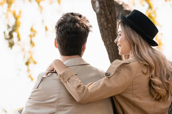 Rubia mujer en sombrero tocando y mirando novio fuera - foto de stock