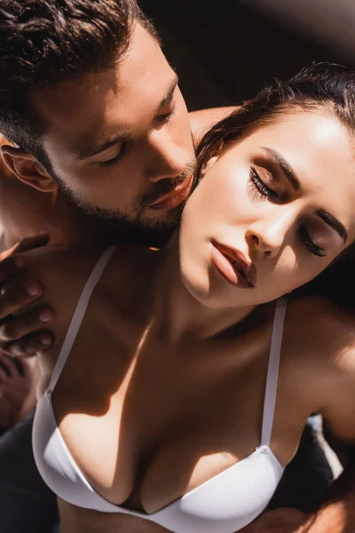 Hochwinkelaufnahme eines hemdlosen Mannes, der junge sexy Frau mit geschlossenen Augen berührt — Stockfoto