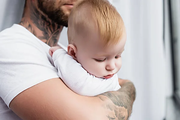 Enfoque selectivo de bebé niño en manos de padre joven - foto de stock