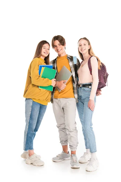 Adolescentes sorridentes com mochilas e cadernos olhando para a câmera no fundo branco — Fotografia de Stock