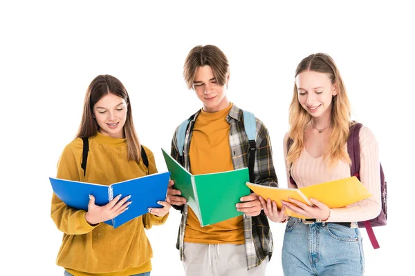 Adolescentes sorrindo enquanto olham para cadernos isolados em branco — Fotografia de Stock
