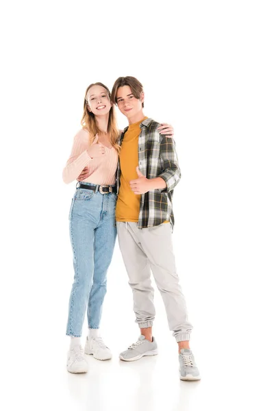 Smiling teenagers embracing and showing thumbs up gesture on white background — Stock Photo