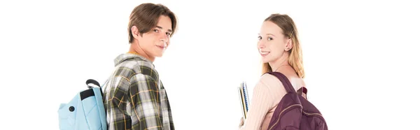 Foto panorámica de adolescentes con mochilas y cuadernos sonriendo a cámara aislada en blanco - foto de stock