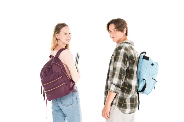 Adolescenti con libri di copia e zaini sorridenti alla fotocamera isolata su bianco — Foto stock