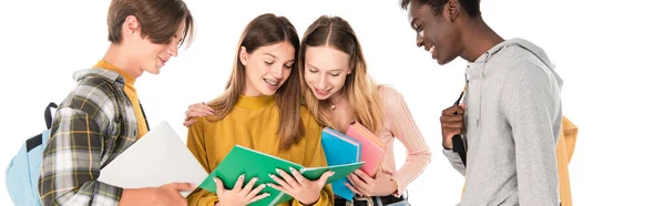 Website header of smiling multiethnic teenagers looking at notebook isolated on white — Stock Photo