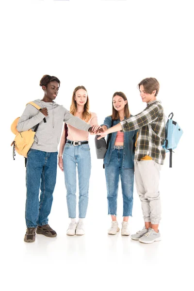 Sonrientes adolescentes multiculturales tomados de la mano sobre fondo blanco - foto de stock