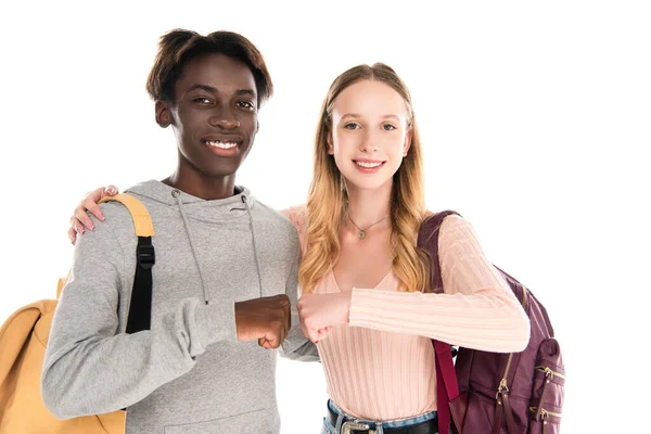 Sonrientes adolescentes multiétnicos haciendo puñetazos aislados en blanco - foto de stock
