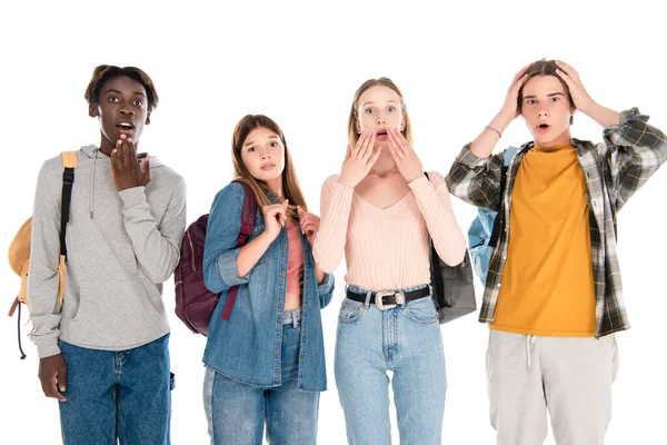 Excited multicultural teenagers with backpacks looking at camera isolated on white — Stock Photo