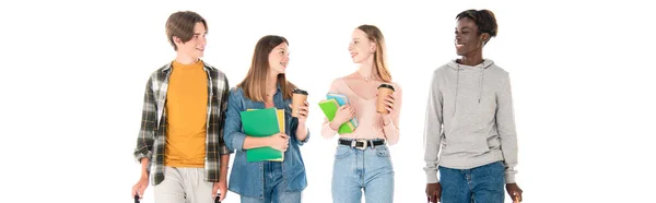 Foto panorámica de adolescentes multiétnicos sonrientes con libros y café para ir aislados en blanco - foto de stock