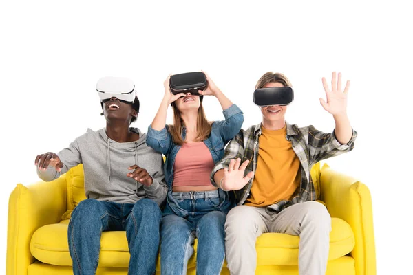 Fröhliche multiethnische Teenager mit vr-Headsets auf gelbem Sofa isoliert auf weißem — Stockfoto