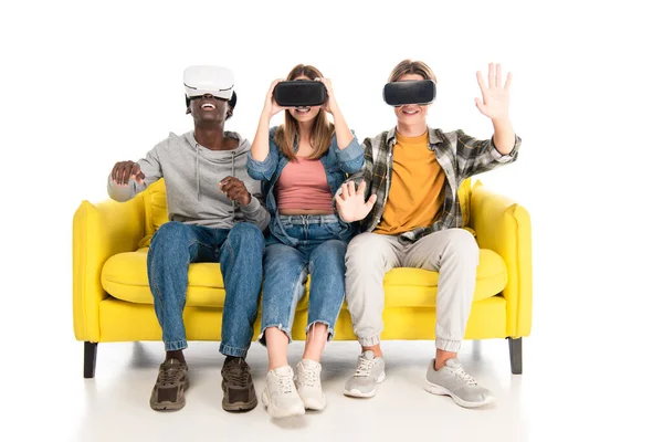 Adolescentes multiétnicos sorrindo ao usar fones de ouvido vr no fundo branco — Fotografia de Stock