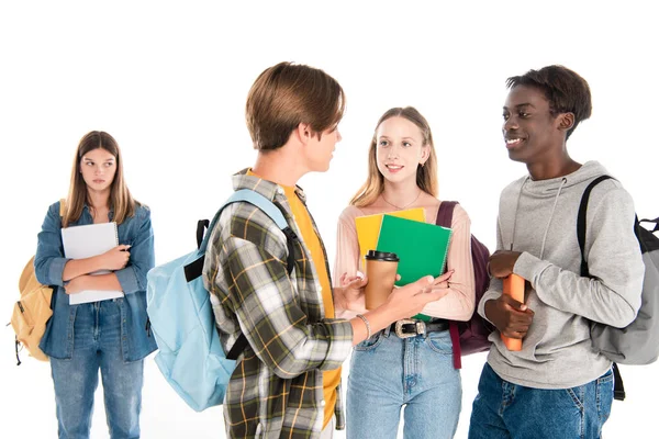 Lächelnde multiethnische Teenager mit Rucksäcken unterhalten sich in der Nähe trauriger Mädchen isoliert auf weiß — Stockfoto