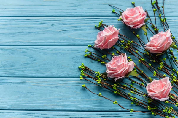 Fundo azul de madeira com ramos florescentes e rosas — Fotografia de Stock