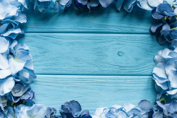 Top view of wooden blue background with floral frame — Stock Photo