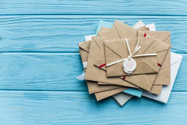 Top view of wooden blue background with envelopes and heart — Stock Photo