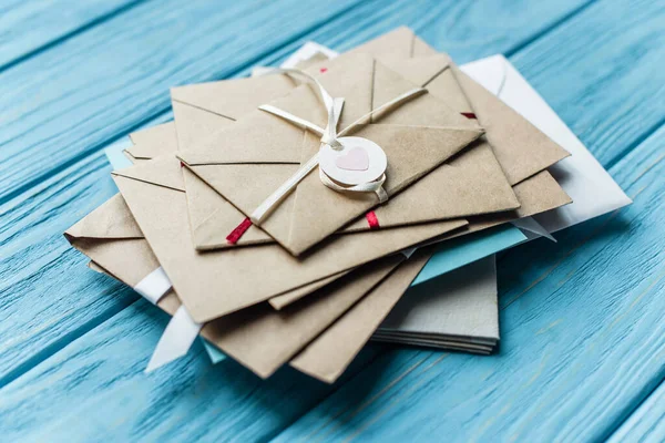 Fundo azul de madeira com envelopes e coração — Fotografia de Stock