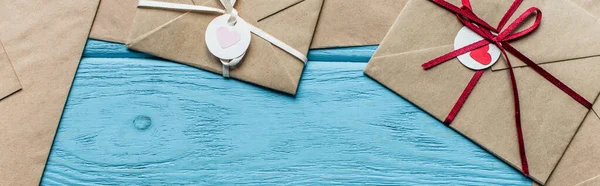 Top view of wooden blue background with envelopes and hearts, panoramic shot — Stock Photo