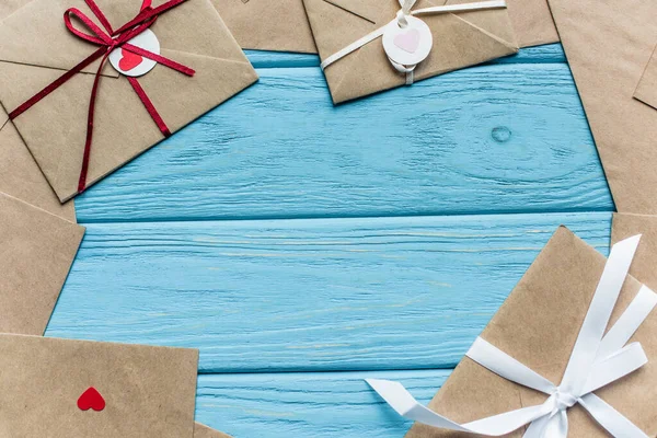 Top view of wooden blue background with envelopes and hearts — Stock Photo