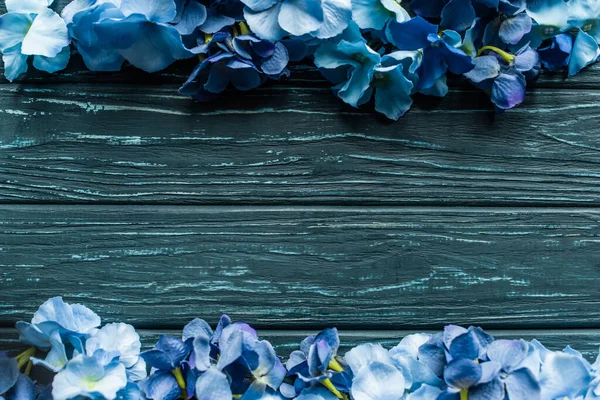 Vista superior de fondo verde madera con bordes florales azules - foto de stock