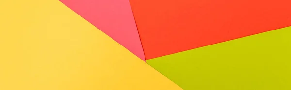 Вид зверху барвистий абстрактний жовтий, червоний, зелений і рожевий паперовий фон, панорамний знімок — стокове фото