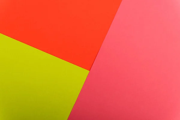 Вид зверху барвистий абстрактний червоний, зелений і рожевий паперовий фон — стокове фото