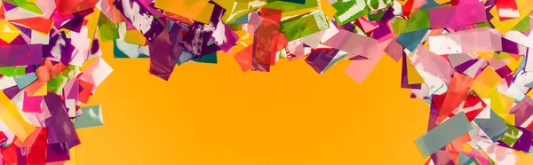 Draufsicht auf bunten, hellen Konfetti-Rahmen auf orangefarbenem Hintergrund, Panoramaaufnahme — Stockfoto