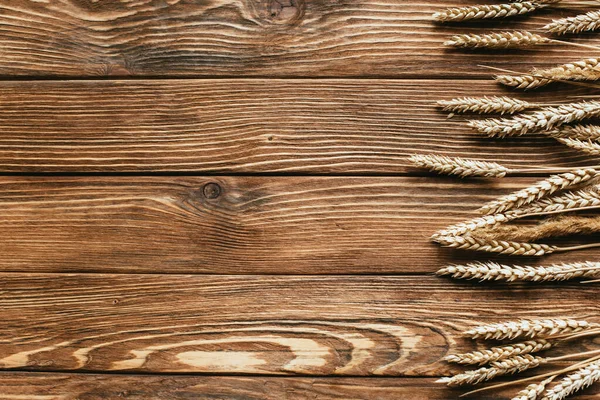 Top view of wheat ears border on wooden background — Stock Photo