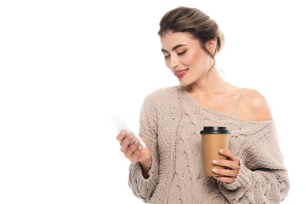 Stylische Frau im Strickpullover, Kaffee to go in der Hand, während sie auf dem Handy chatten isoliert auf weiß — Stockfoto