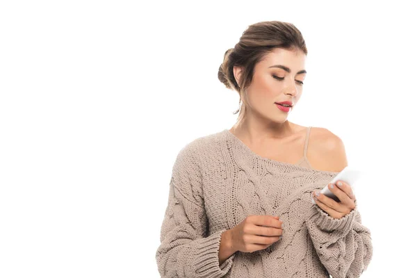 Чуттєва, стильна жінка в ажурному светрі спілкується на смартфоні ізольовано на білому — стокове фото